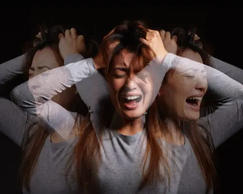 Shot of a young woman experiencing mental illness against a black background