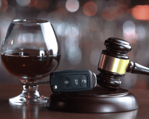 A judge’s gavel resting beside a car key and a glass of alcohol, symbolizing the legal consequences of a DUI conviction for commercial drivers and CDL holders in San Diego under California law.