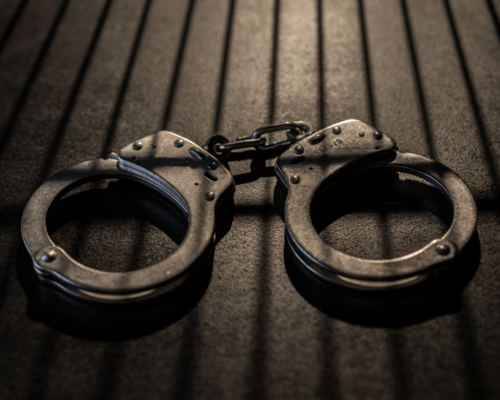 A pair of handcuffs on a dark surface represents the seriousness of child endangerment charges in North County California and the potential for misdemeanor or felony prosecution under Penal Code 273a depending on risk, intent, and case facts.